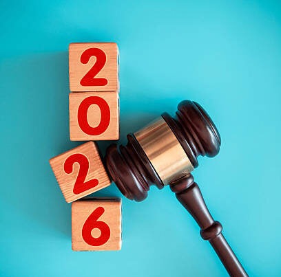 A judge's gavel rests beside wooden blocks stacked vertically, displaying the numbers 2026 in red on a blue background.