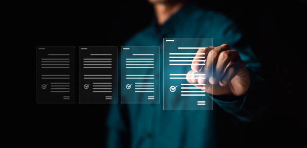 A person in a dark shirt interacts with floating transparent virtual documents, selecting one with a check mark, symbolizing digital document management or electronic approval. The background is dark and blurred.