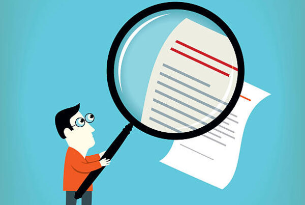 Cartoon of a man holding a large magnifying glass, examining a document with text and red lines, on a blue background. The magnifying glass makes part of the document appear larger.